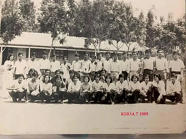 Ảnh đen trắng cũ: tập thể học sinh Khóa 7 chụp ảnh chung trước dãy phòng học, năm 1985